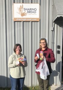 Shannon Mills, Director at Sharing Bread Soup Kitchen, and Carol Galstad from Essential Web Strategies at Sharing Bread Soup Kitchen holding the 'food bag' items outside the Sharing Bread Soup Kitchen in Brainerd Minnesota